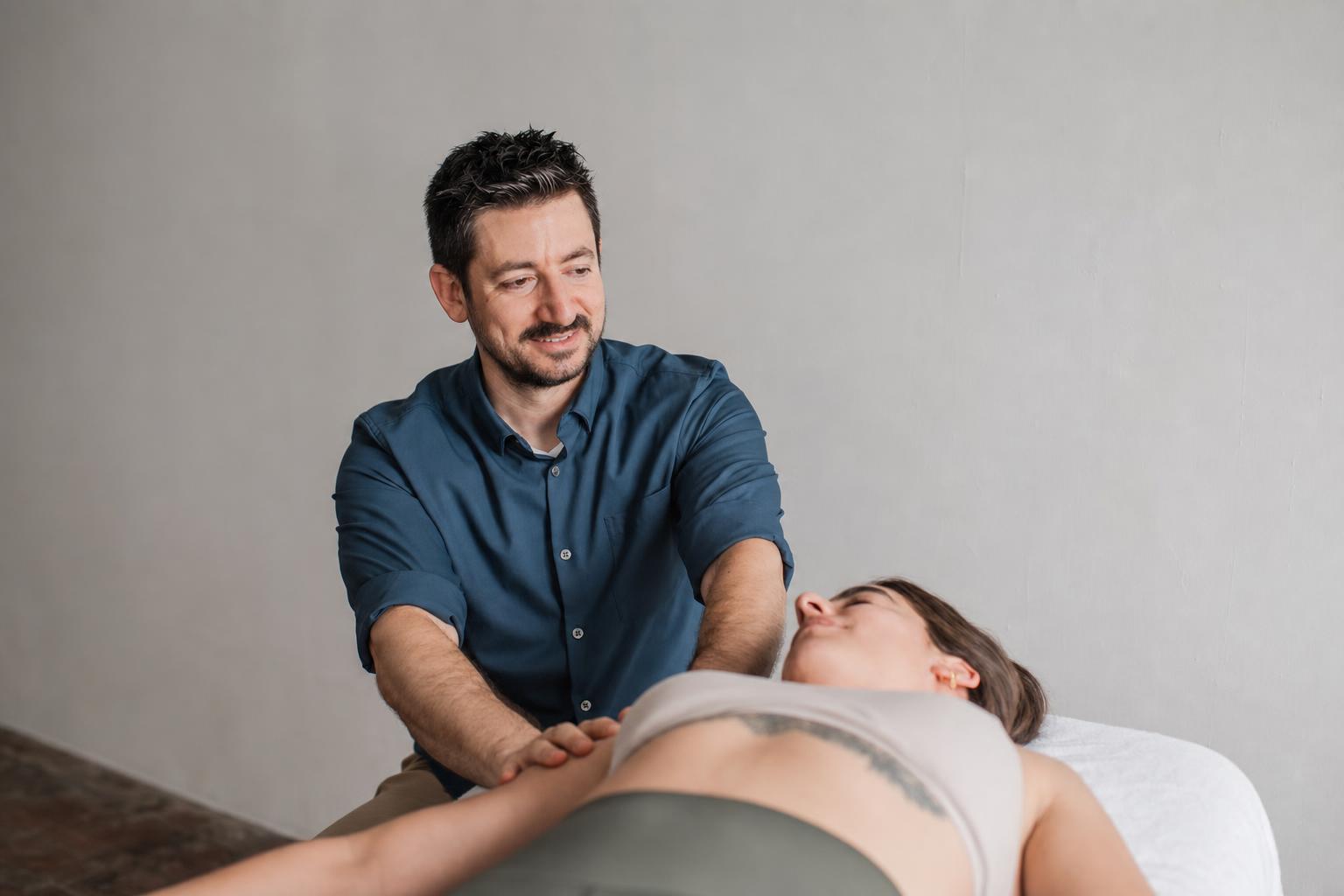 Ryan smiling while working with a client during a Rolfing session